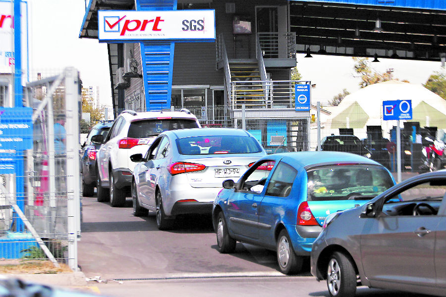 Fila de autos esperando en planta de revisión técnica en Chile